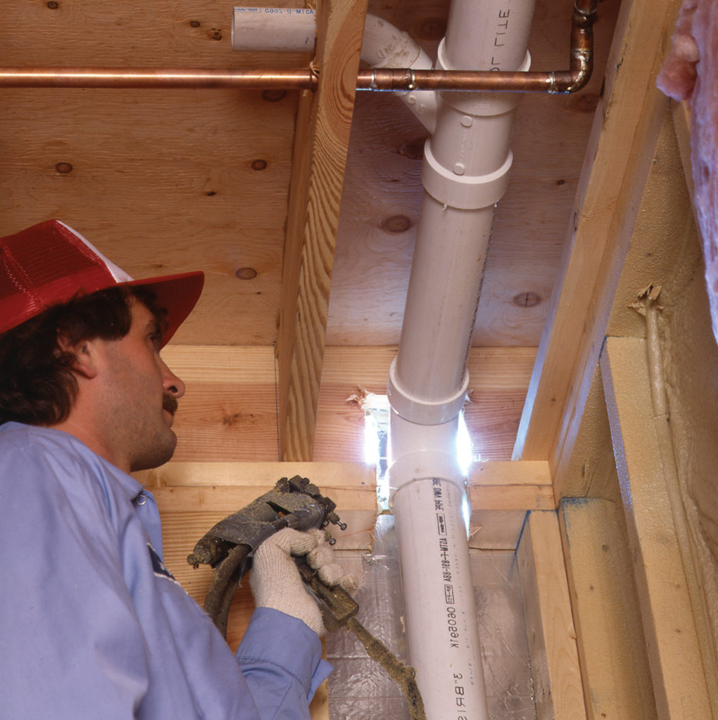 Professional inspecting a wall before insulation